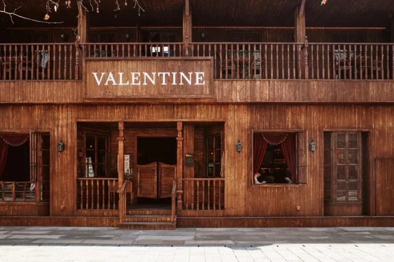 A wooden-bar saloon interior in warm lamplight, photographed in sepia