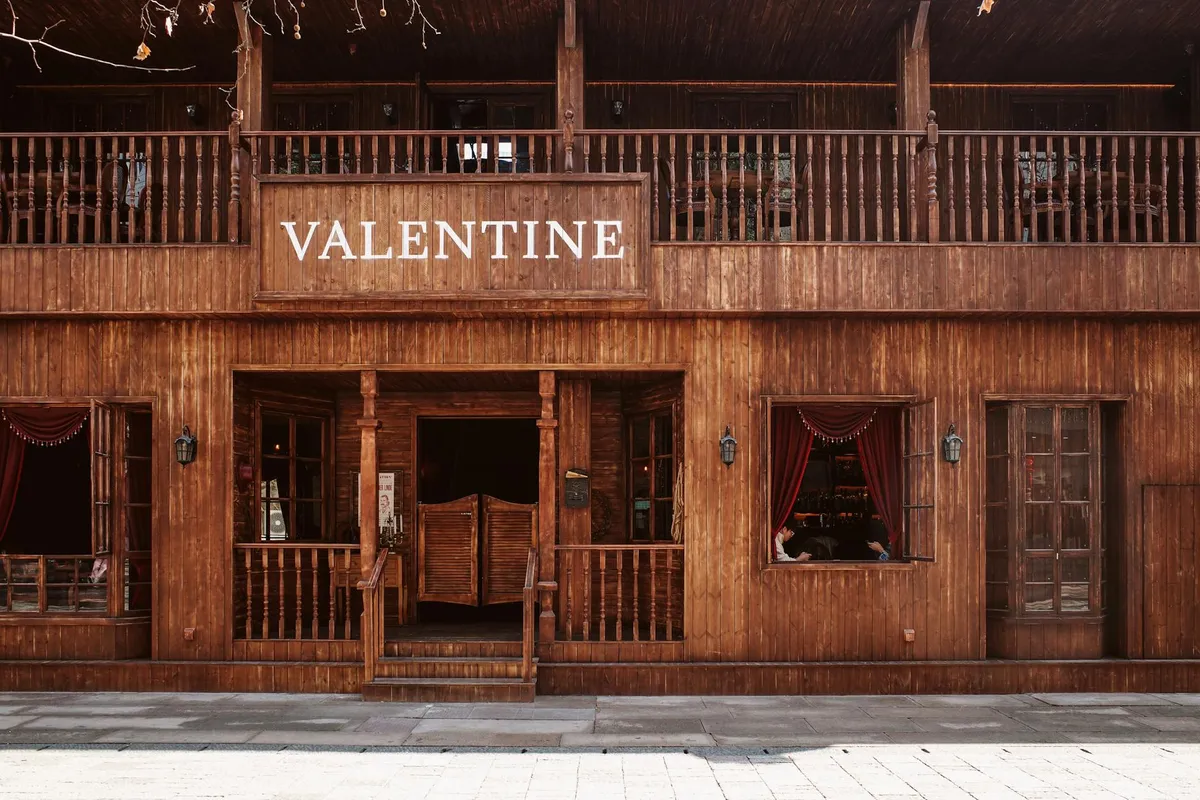 A wooden-bar saloon interior in warm lamplight, photographed in sepia